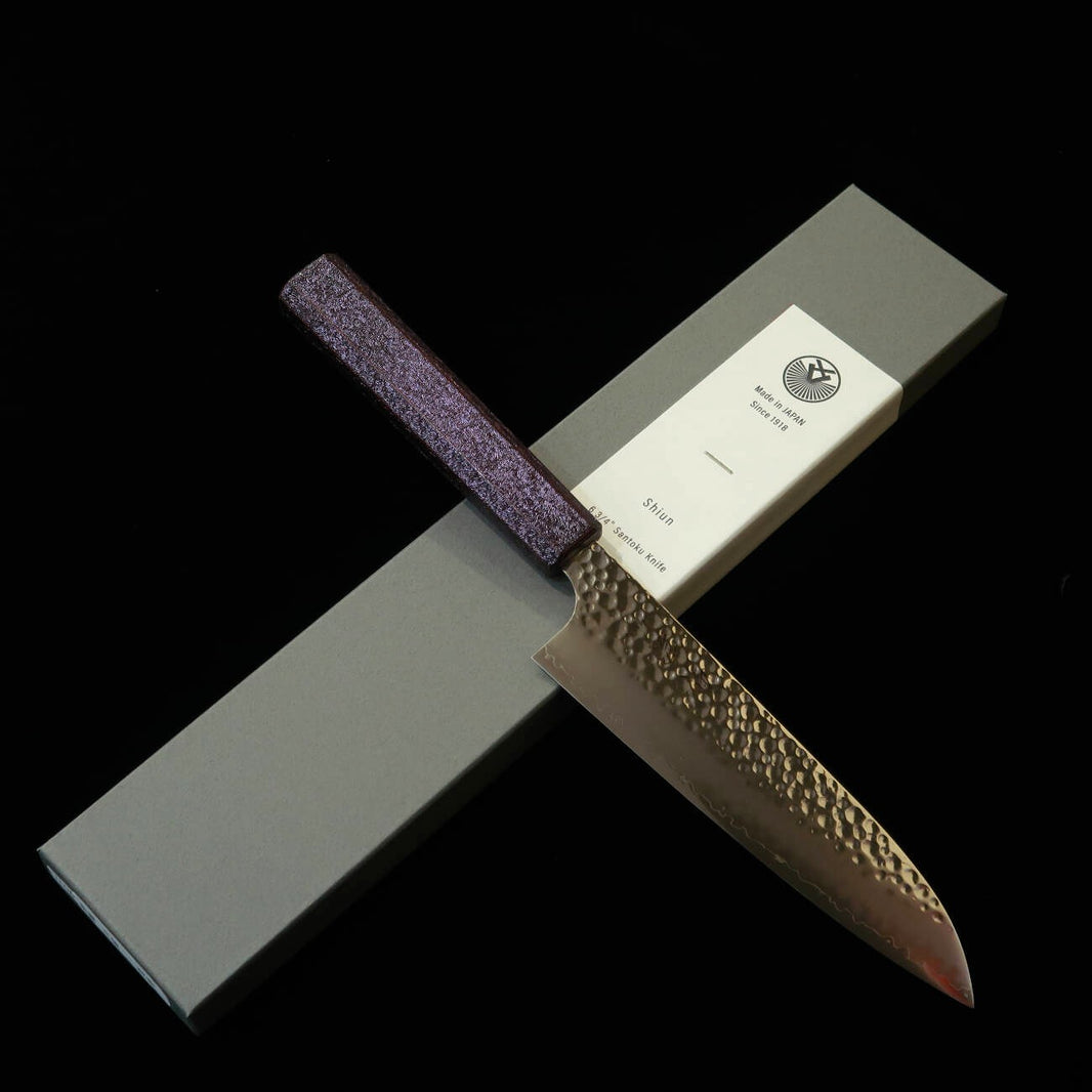 SEKIKANETSUGU Seki Kanetsugu “Shiun”, santoku VG10, martillado, mango octogonal de roble lacado “Monmurasaki” (púrpura) (170 mm)